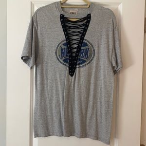 Grey t shirt with black tie in front. New York graphic